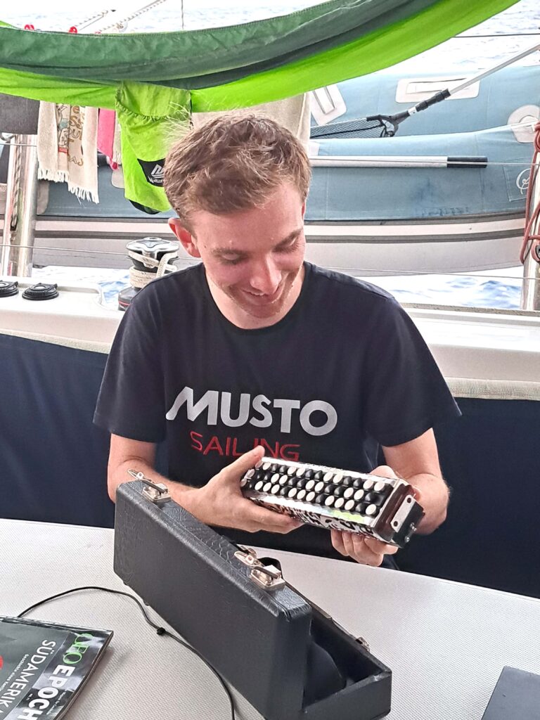 ARC 2023 Tagebuch - Tag 19 - 6. Tag auf See 6 Robin mit seinem Musikinstrument