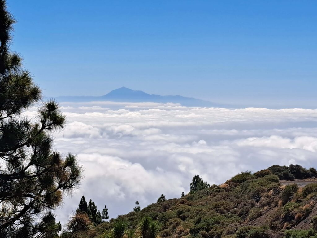 Kanareninsel La Palma - Roque de Los Muchachos - Vom Meer hinauf bis über die Wolken... eine Fotodokumentation 4 Wolkengebilde ueber Land mit Berggipfel im Hintergrund